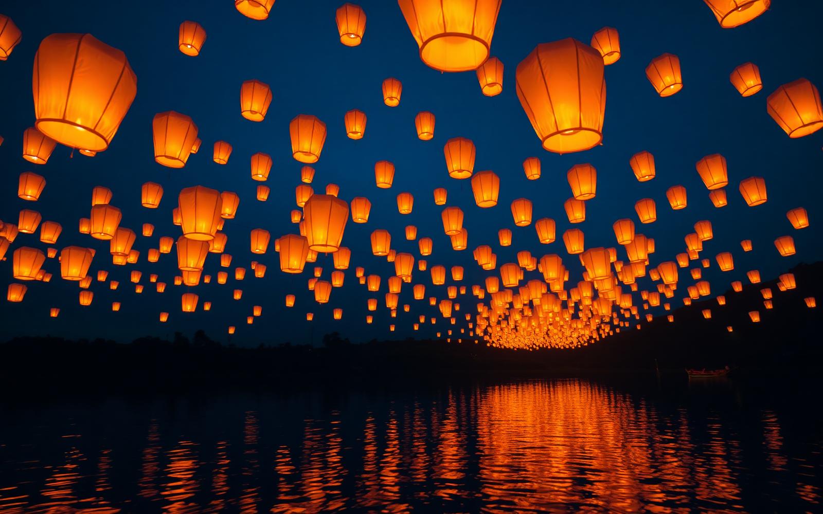 Floating paper lanterns rising over dark water at night, the signature sequence of the Tangled story